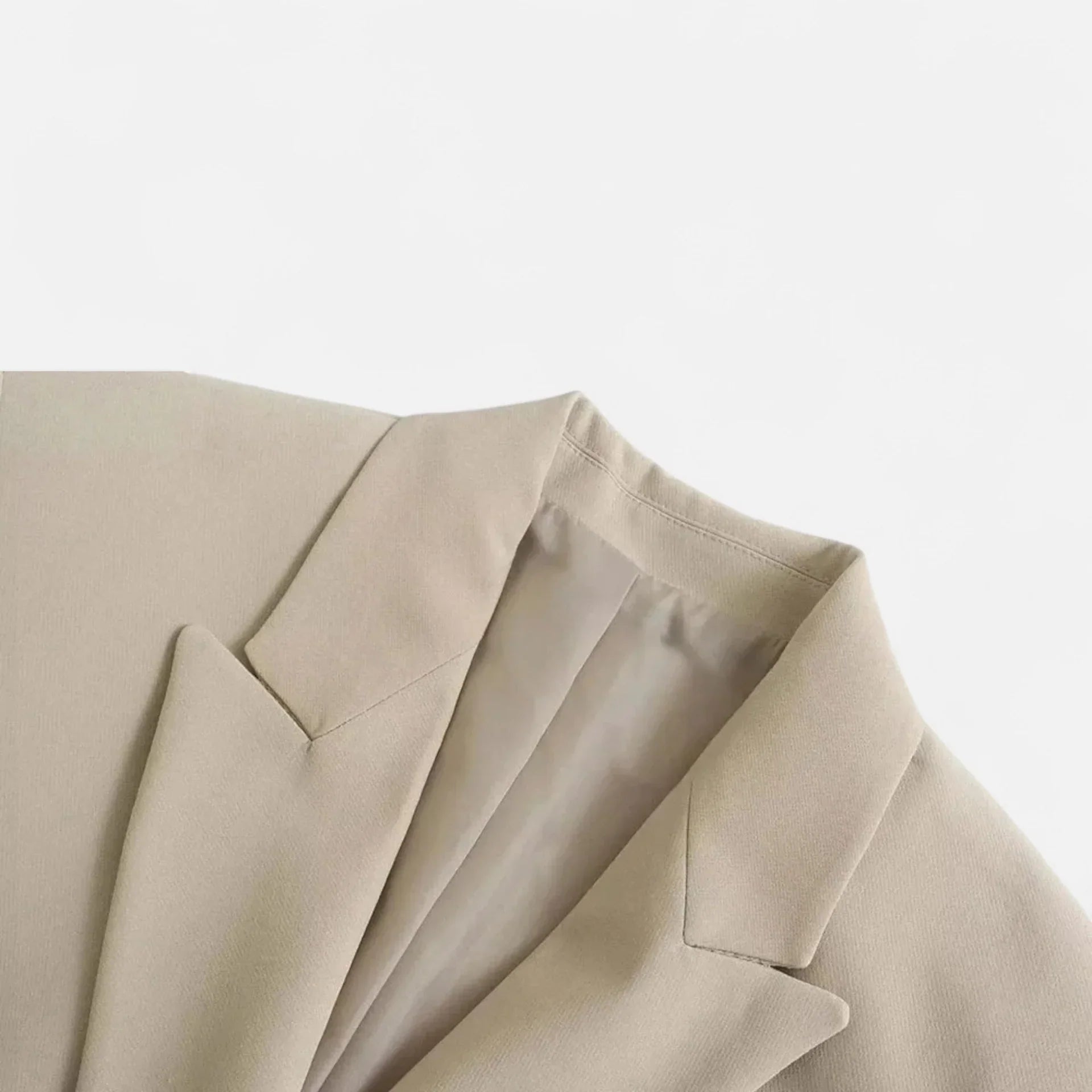 Close-up of a beige suit jacket on a light gray background
