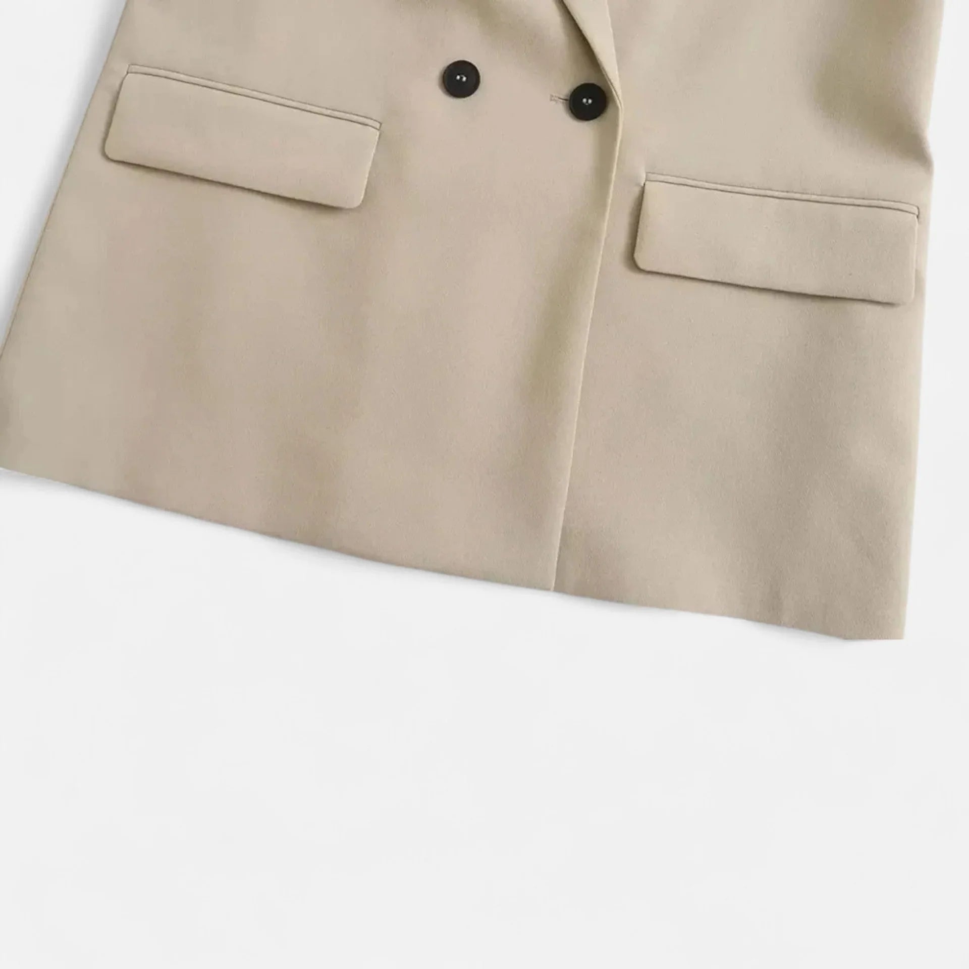 Close-up of a beige suit jacket with two buttons on a white background