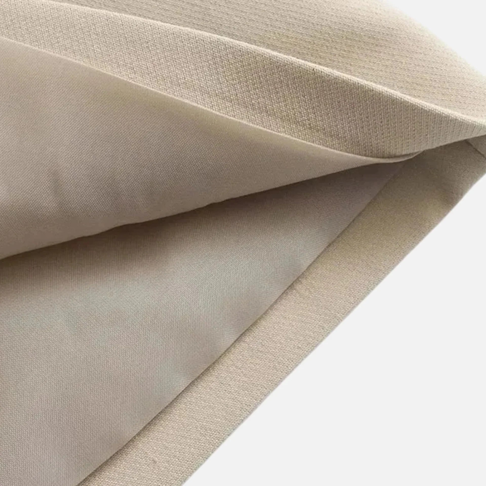 Close-up of beige fabric with a subtle texture on a white background