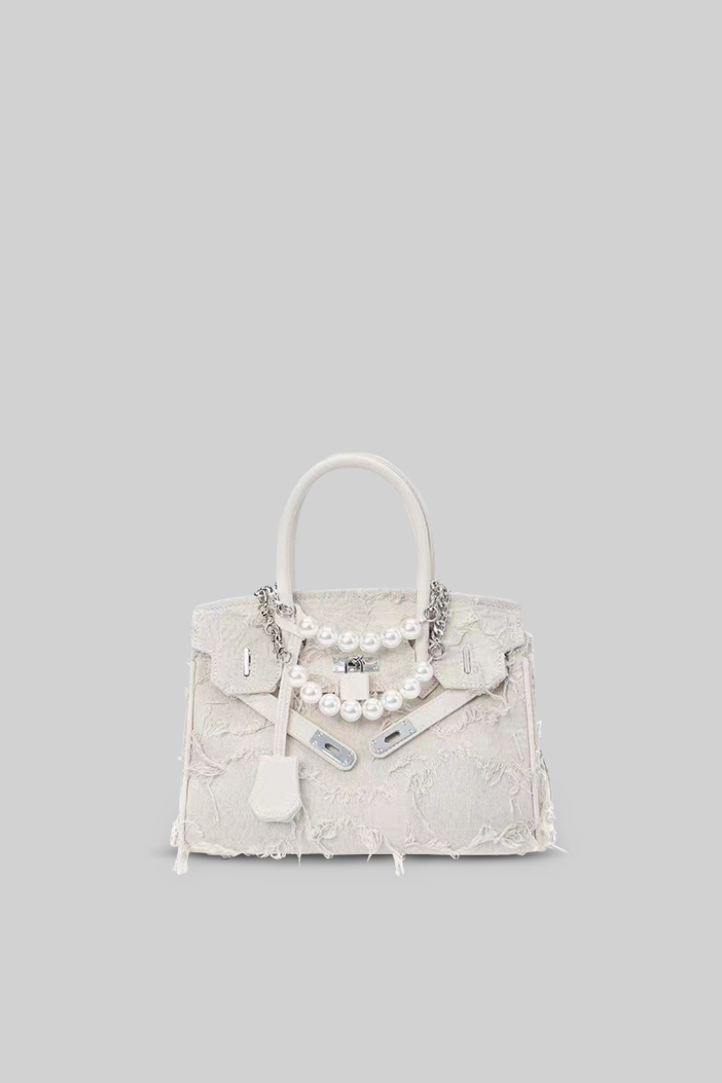 White handbag with pearls on a gray background