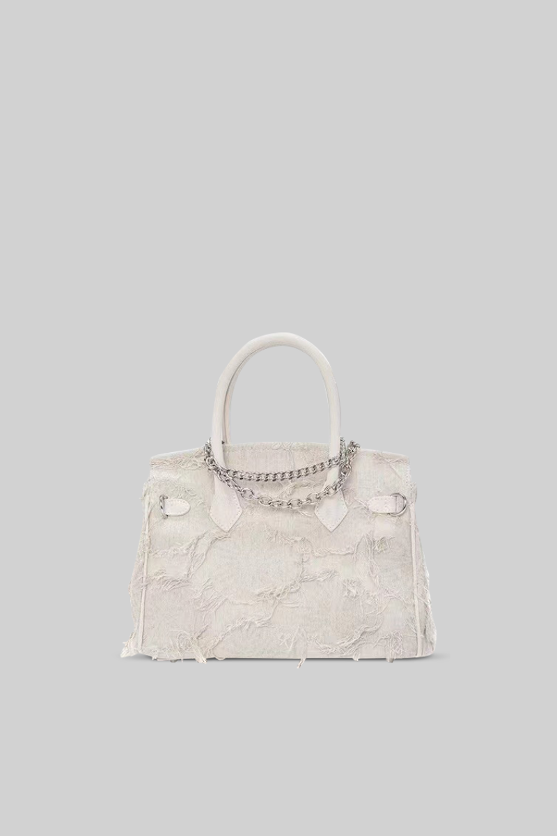 White handbag with chain detail on a gray background