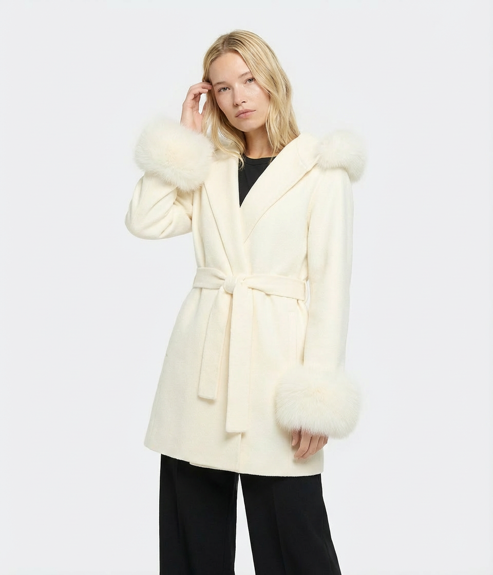 Woman wearing a cream-colored coat with fur trim on a white background