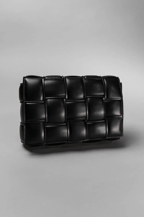 Black woven clutch bag on a gray background
