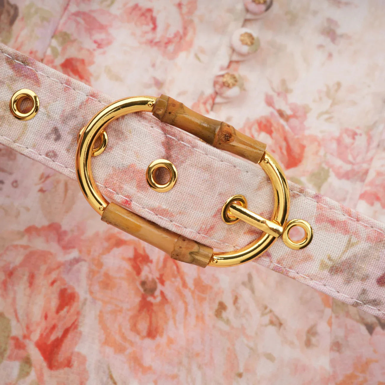 Gold and bamboo carabiner on a floral background