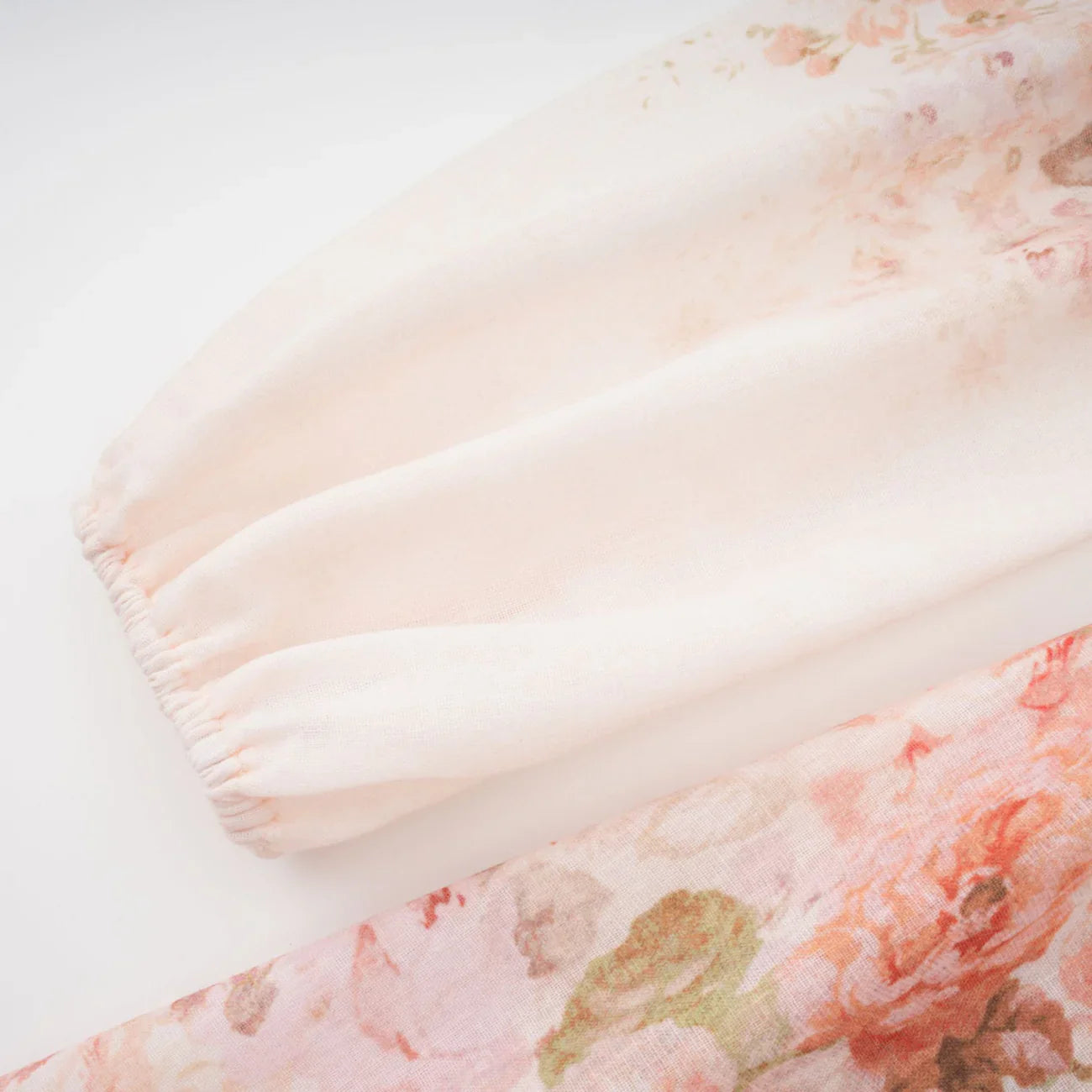 Floral patterned fabric with soft pink and green colors on a light background