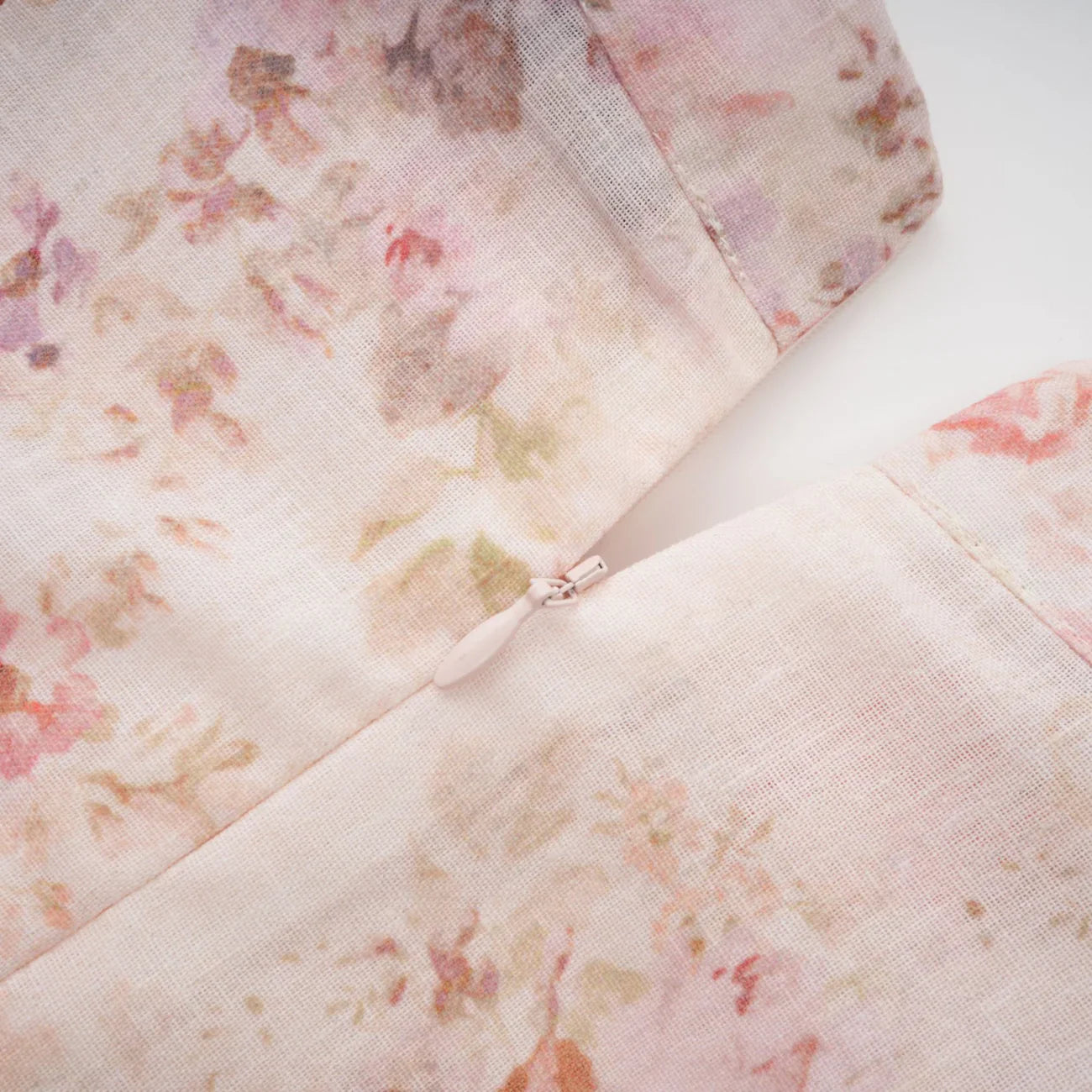 Floral patterned fabric with a zipper detail on a white background