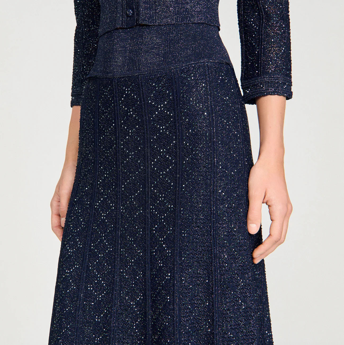 Navy blue textured skirt worn by a person on a light gray background