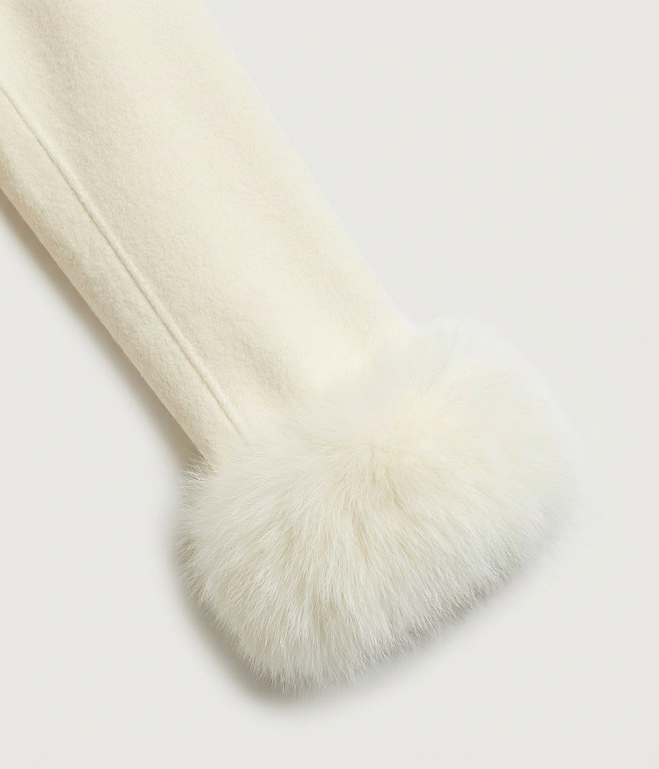 Cream-colored blanket with fur trim on a light gray background