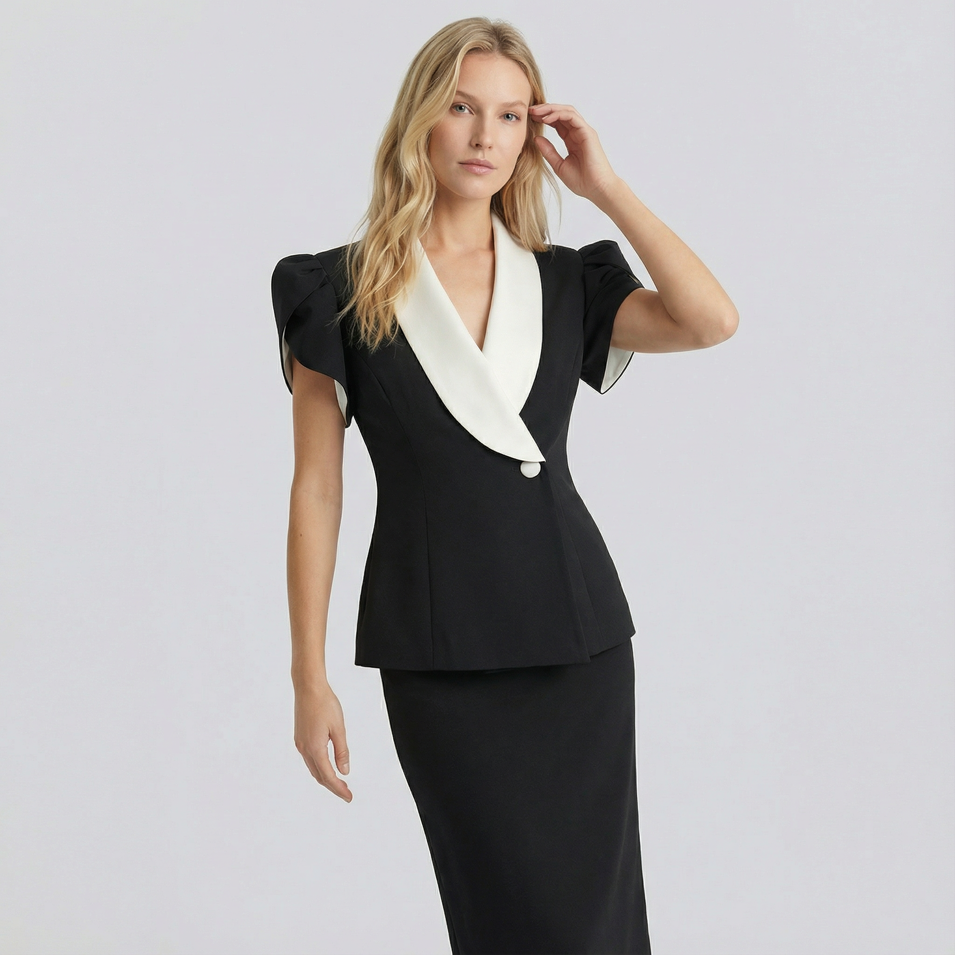 Woman wearing a black dress with a white collar against a light gray background