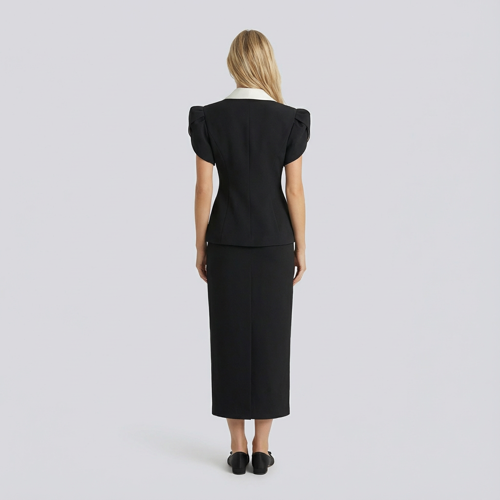 Woman wearing a black outfit with puffed sleeves on a light gray background