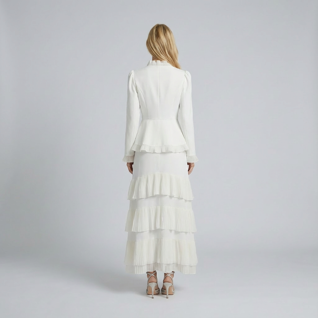Woman wearing a white outfit with a layered skirt on a plain background