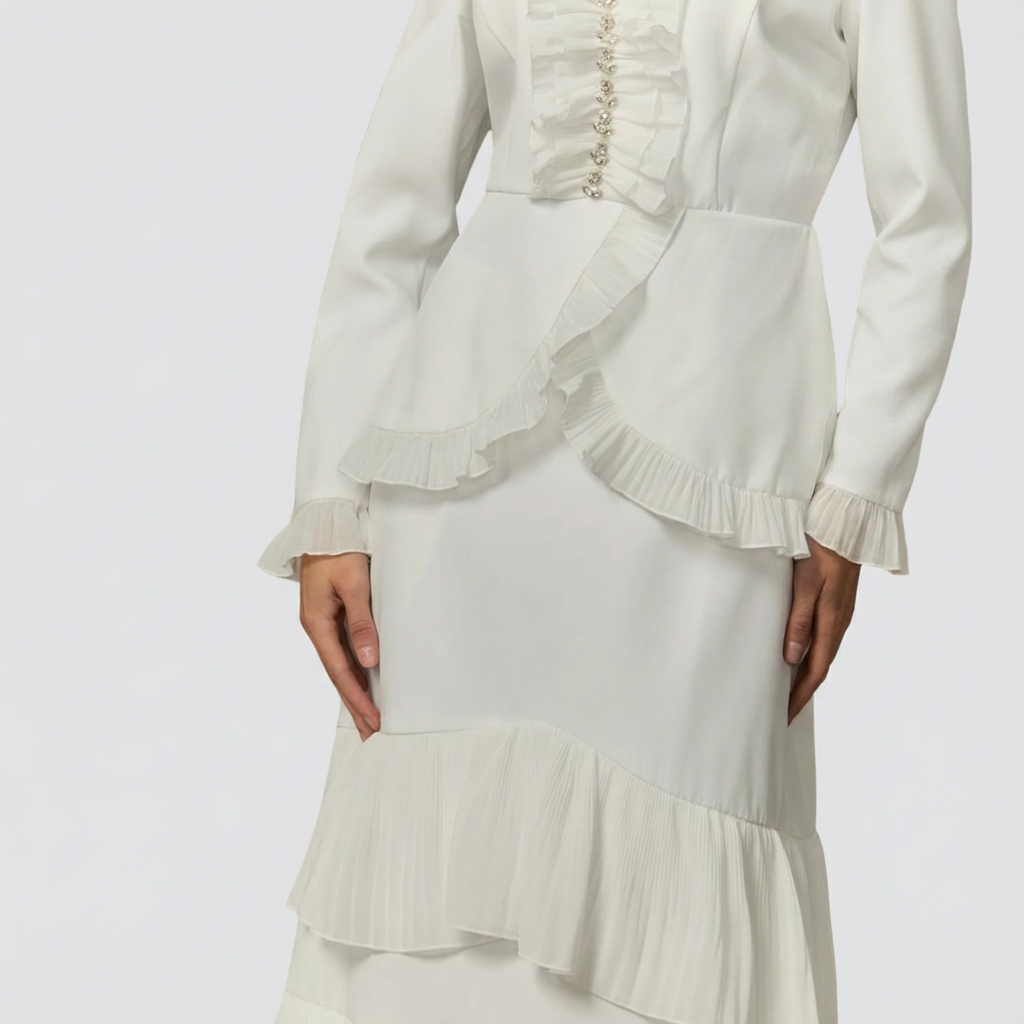 White outfit with ruffled details on a plain background