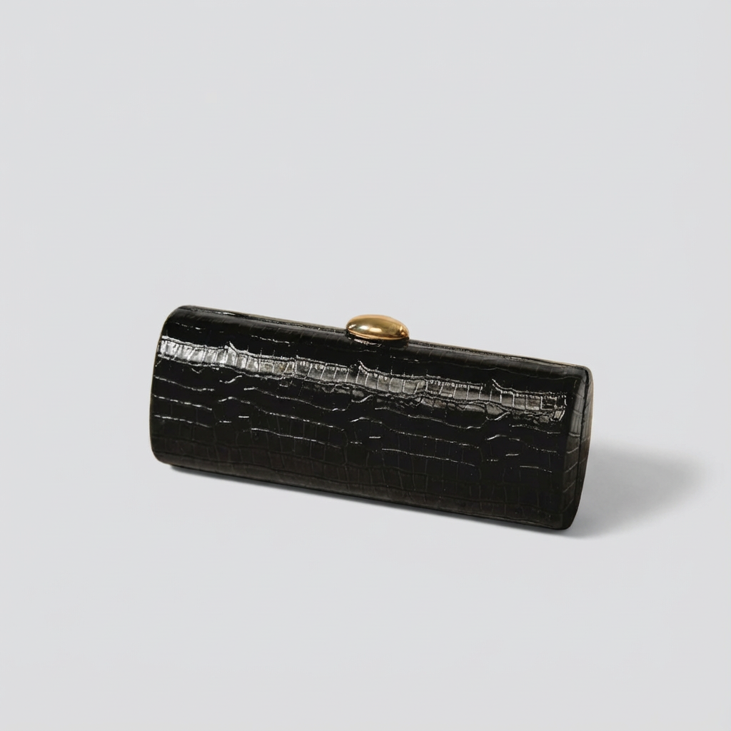 Black crocodile skin clutch bag with gold clasp on a light gray background