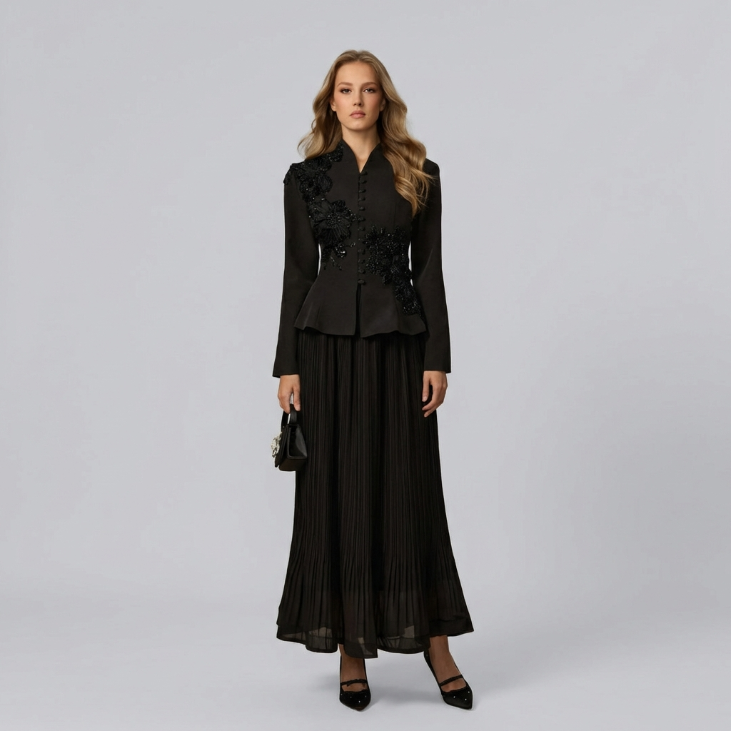 Woman wearing a black outfit with floral details on a gray background