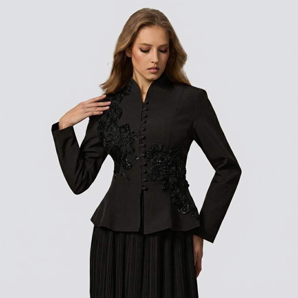 Woman wearing a black jacket with floral embellishments on a light gray background