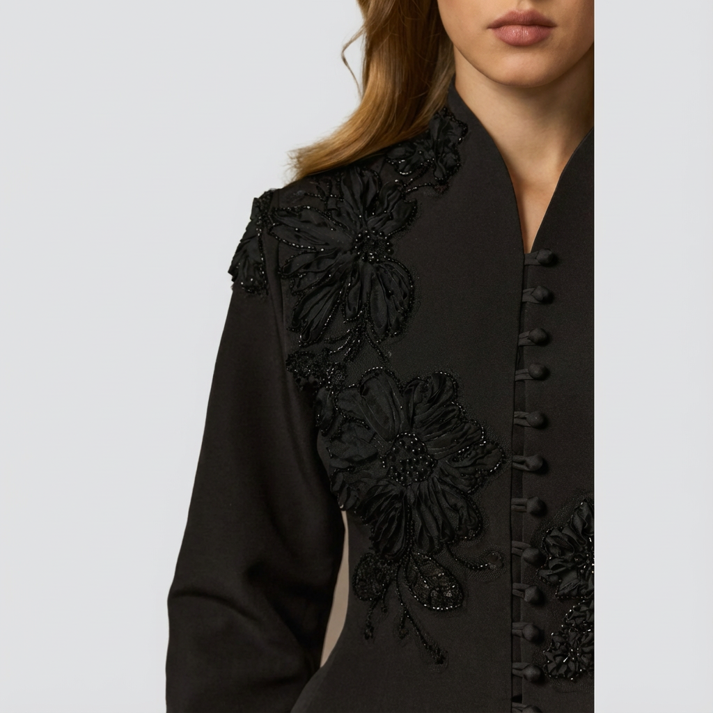 Black embroidered jacket on a plain background