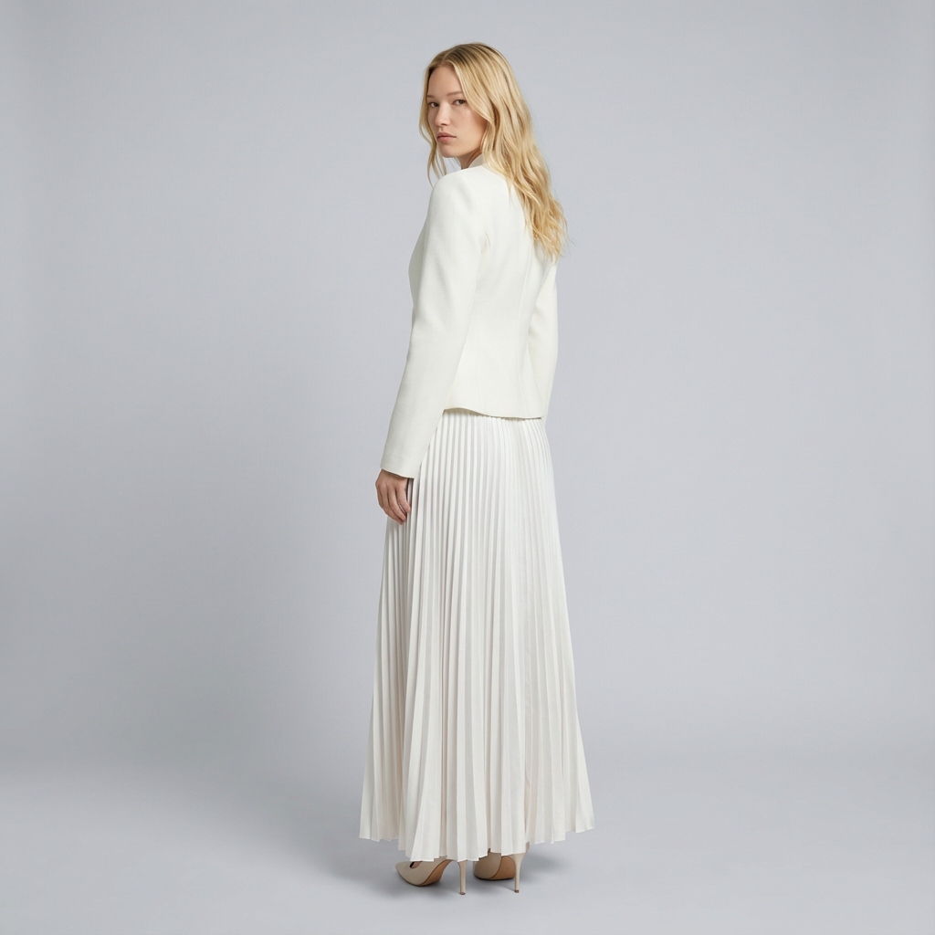 Woman wearing a white outfit with a pleated skirt on a gray background