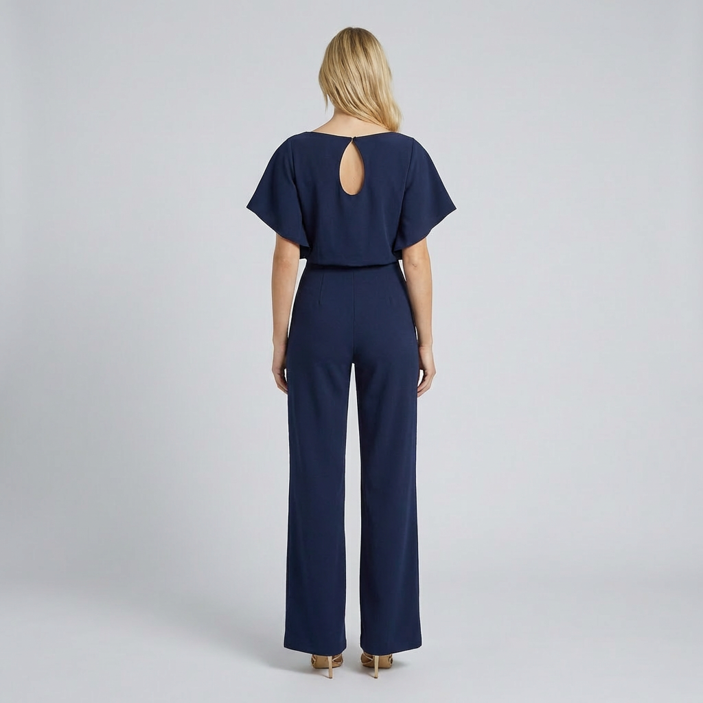 Woman wearing a navy blue jumpsuit on a light gray background