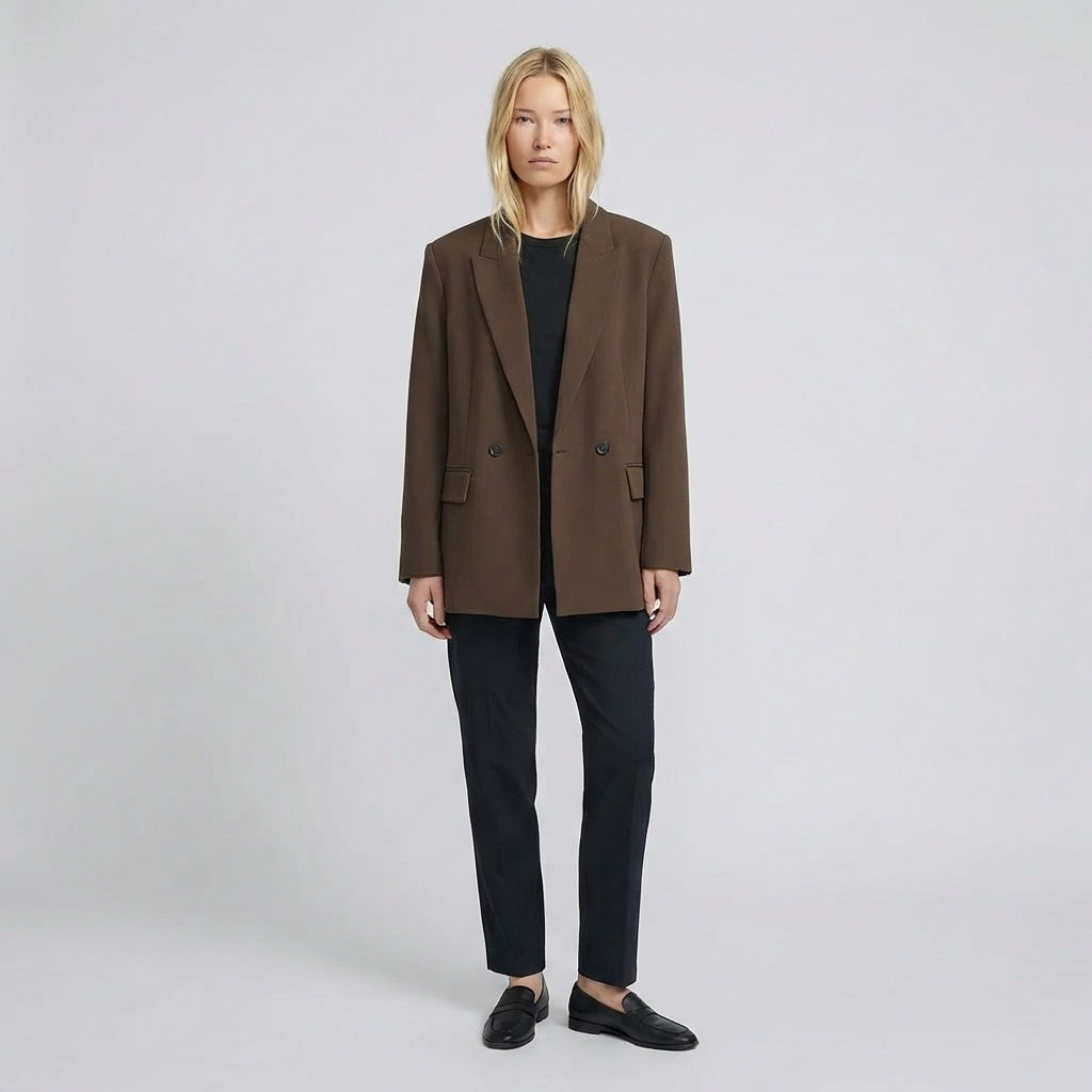 Person wearing a brown coat and black pants on a white background