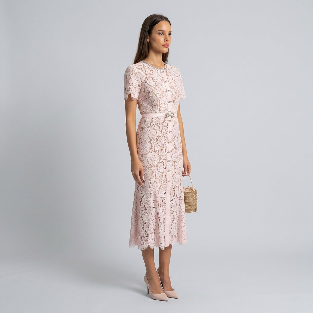 Woman wearing a light pink lace dress on a gray background