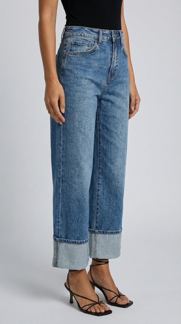 Person wearing blue jeans on a plain background