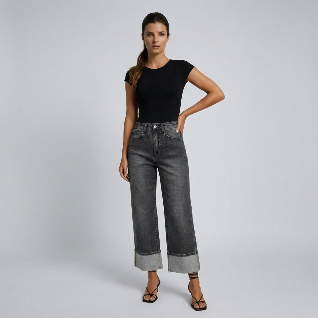 Woman wearing black top and gray wide-leg jeans on a light gray background